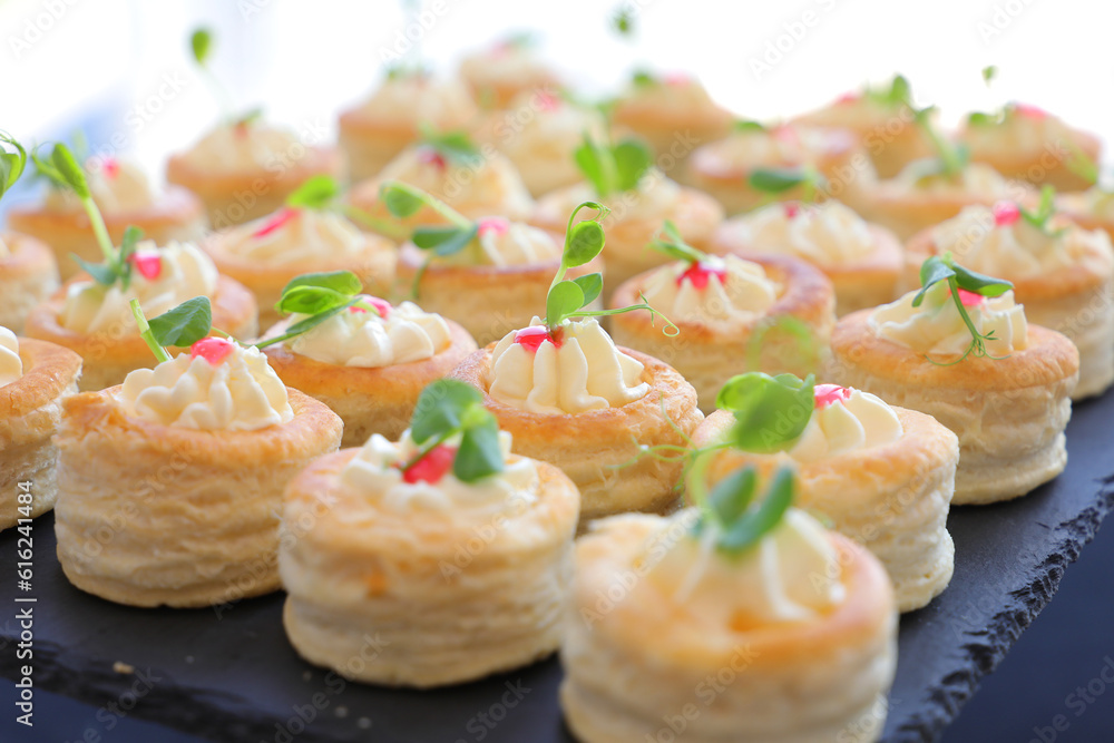 Appetizer puff pastry stuffed with soft cream cheese decorated with fresh micro plants. Selective focus. Appetizer puff pastry stuffed with soft cream cheese decorated with fresh micro plants. Selective focus.