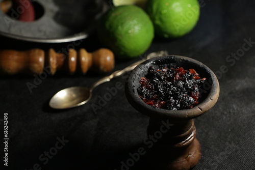 bowl with tobacco for hookah. narghile smoking. berries and fruits on a dark background.