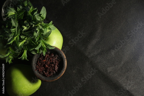 bowl with tobacco for hookah. shiisha smoking. berries and fruits on a black background.