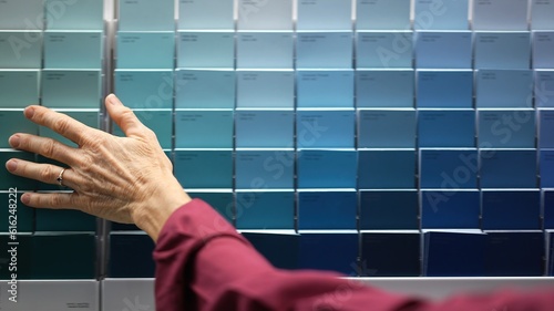 Obraz na plátně Closeup of womans hands looking at paint chips in a hardware store