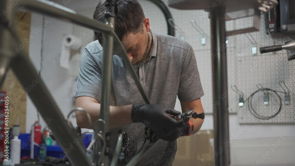 Bicycle mechanic holding syringe with brake fluid during brake bleeding process. Cycle repairman injects brake fluid into hydraulic brakes on bike in workshop. Maintenance cycle brake disc system. Bicycle mechanic holding syringe with brake fluid during brake bleeding process. Cycle repairman injects brake fluid into hydraulic brakes on bike in workshop. Maintenance cycle brake disc system.