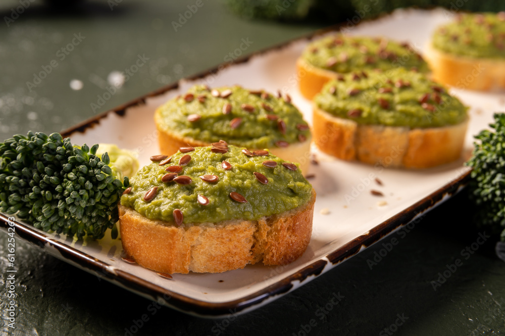 Mashed broccoli or green peas on slices of bread, sprinkled with flax seeds. Broccoli puree.