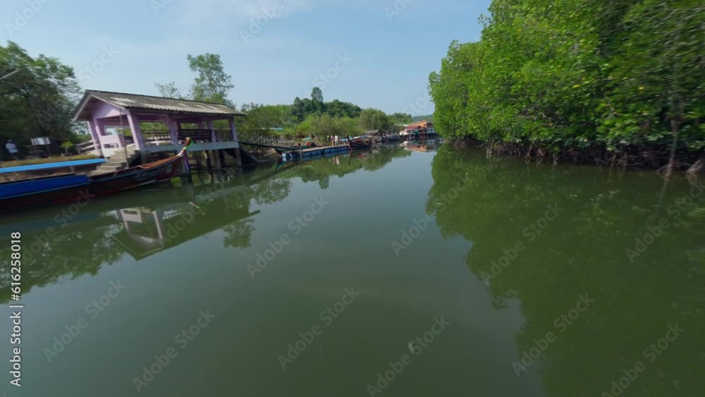 Low dynamic flying over Asian village embankment boat water river local rural house green forest aerial view. FPV sport drone close low shot tropical countryside port harbor fishing ship sunny scenery Low dynamic flying over Asian village embankment boat water river local rural house green forest aerial view. FPV sport drone close low shot tropical countryside port harbor fishing ship sunny scenery