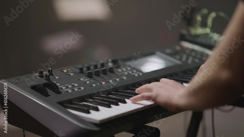 Male hands play synthesizer. Fingers press keys. Male musician, piano accompanist on black and white keyboards during concert show on stage. Close-up