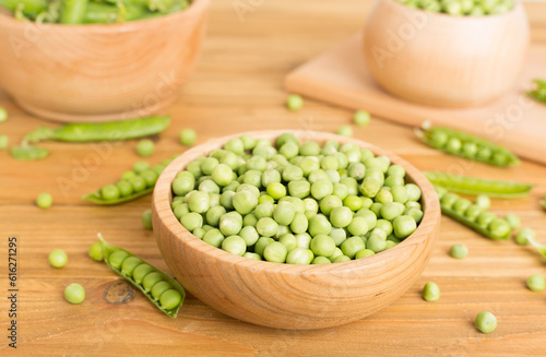 Composition with fresh green peas on wooden table