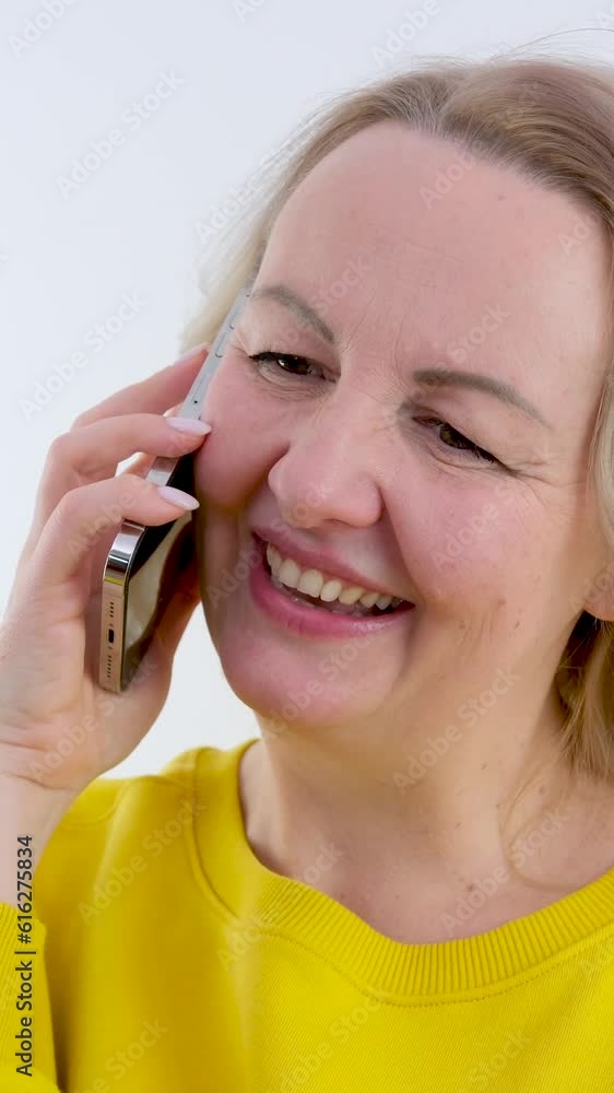 Positive young woman talking by smartphone with family or friends share news in the light room at home Relaxed girl has a pleasant conversation on mobile phone device indoors. High quality 4k footage Positive young woman talking by smartphone with family or friends share news in the light room at home Relaxed girl has a pleasant conversation on mobile phone device indoors. High quality 4k footage