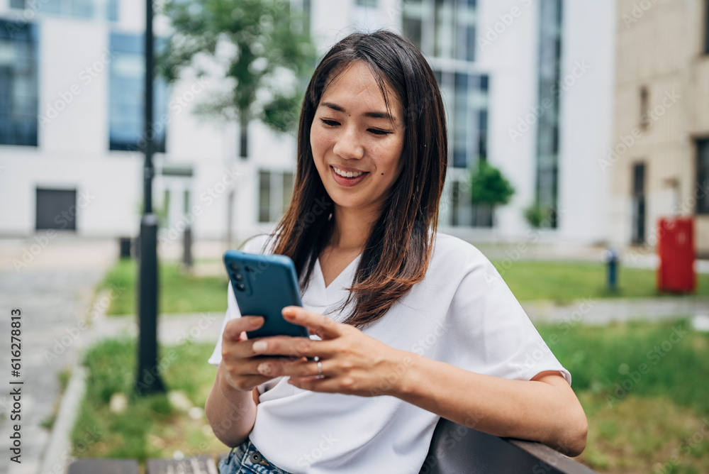Young Japanese woman using smart phone in the city
Young Japanese woman using smart phone in the city