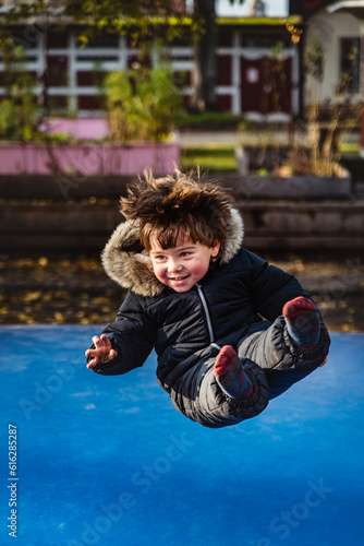 Foto Joyful kid flying sit while jumping pole vault