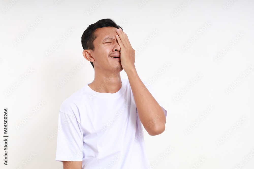 Asian man crying frustrating while covering his face. Isolated on white background Asian man crying frustrating while covering his face. Isolated on white background
