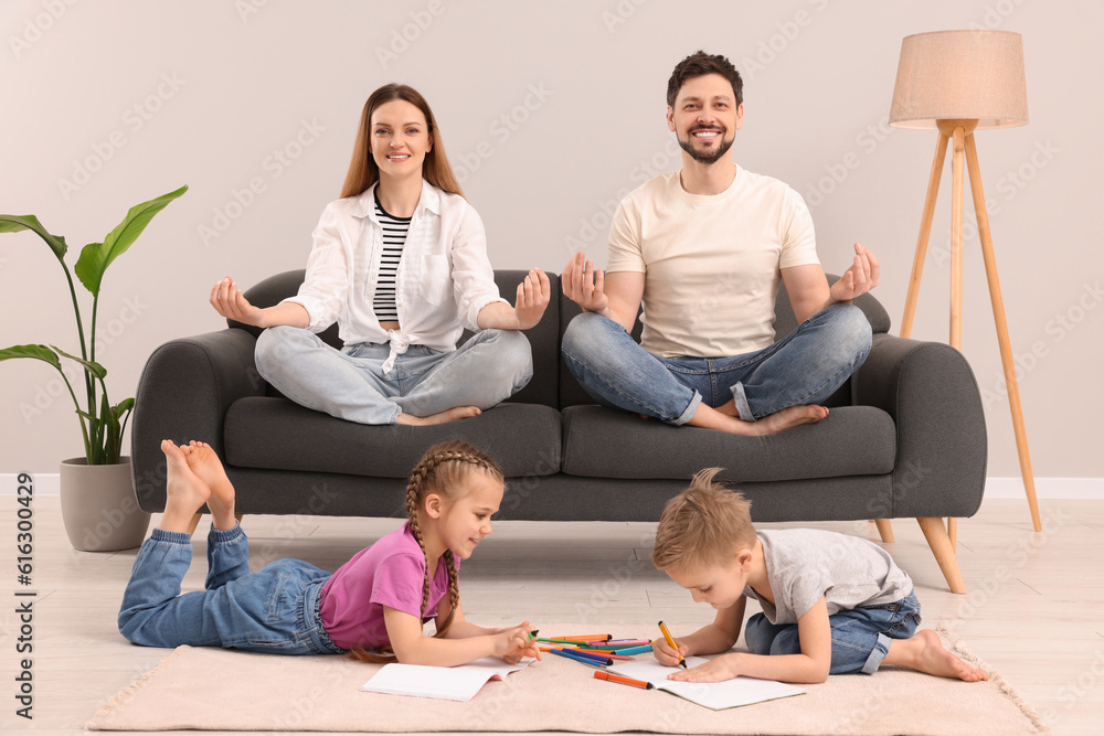 Parents meditating while their children painting at home