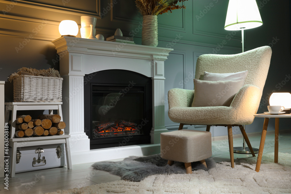 Beautiful fireplace, different decor and armchair in living room. Interior design Beautiful fireplace, different decor and armchair in living room. Interior design
