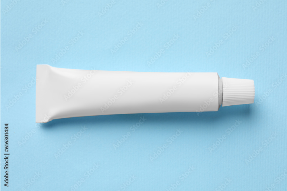Tube of ointment on light blue background, top view. Space for text Tube of ointment on light blue background, top view. Space for text