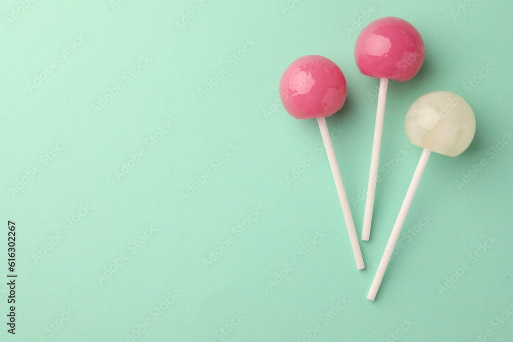 Tasty lollipops on turquoise background, flat lay. Space for text Tasty lollipops on turquoise background, flat lay. Space for text