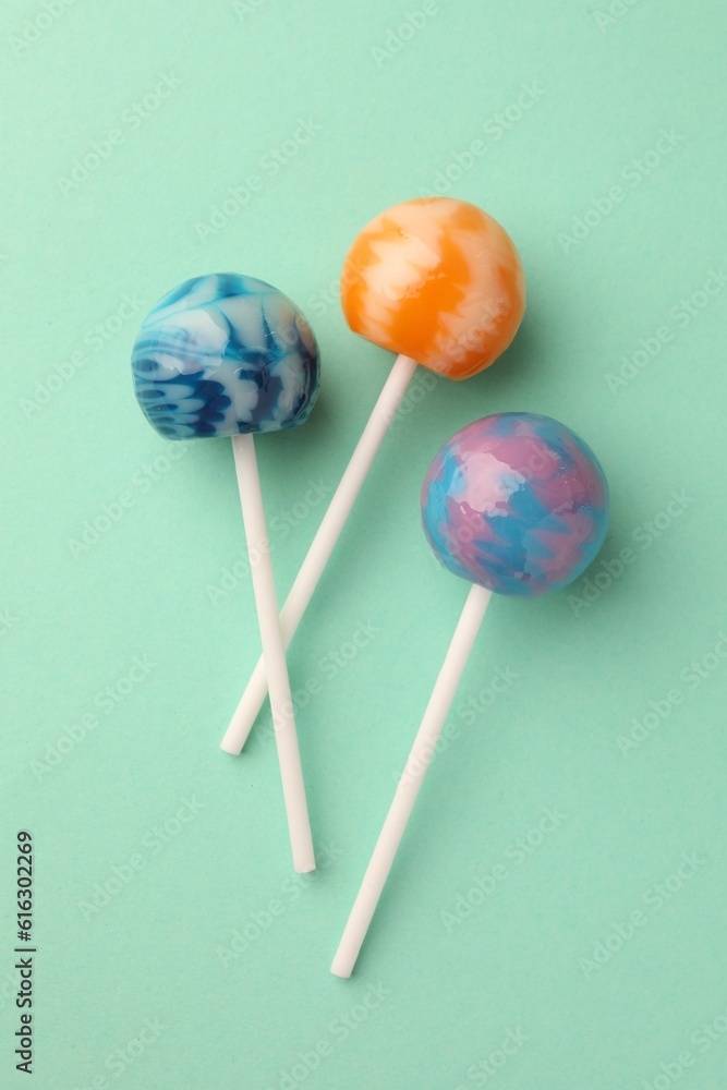 Tasty lollipops on turquoise background, flat lay Tasty lollipops on turquoise background, flat lay