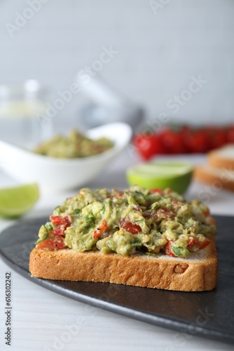Delicious sandwich with guacamole on white table, closeup