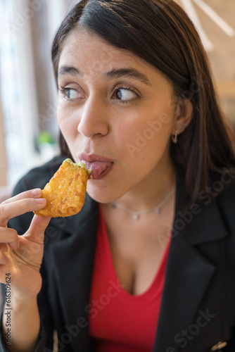 fast food bite details  face of young woman with black hair  trying food and modern lifestyle in studio  delicious