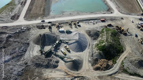 Aerial Flight Over a New Constructions Development Site with High Tower Cranes Building Real Estate.Top Down View of Large construction site with lake, cranes and workers, equipments, heavy machines