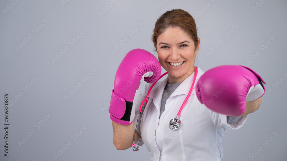 Woman doctor in pink boxing gloves on a white background. Woman doctor in pink boxing gloves on a white background.