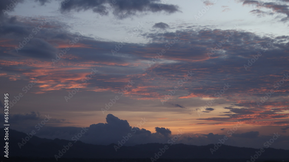 Obraz premium Digital composite of Sunset sky with clouds and mountains in orange and blue