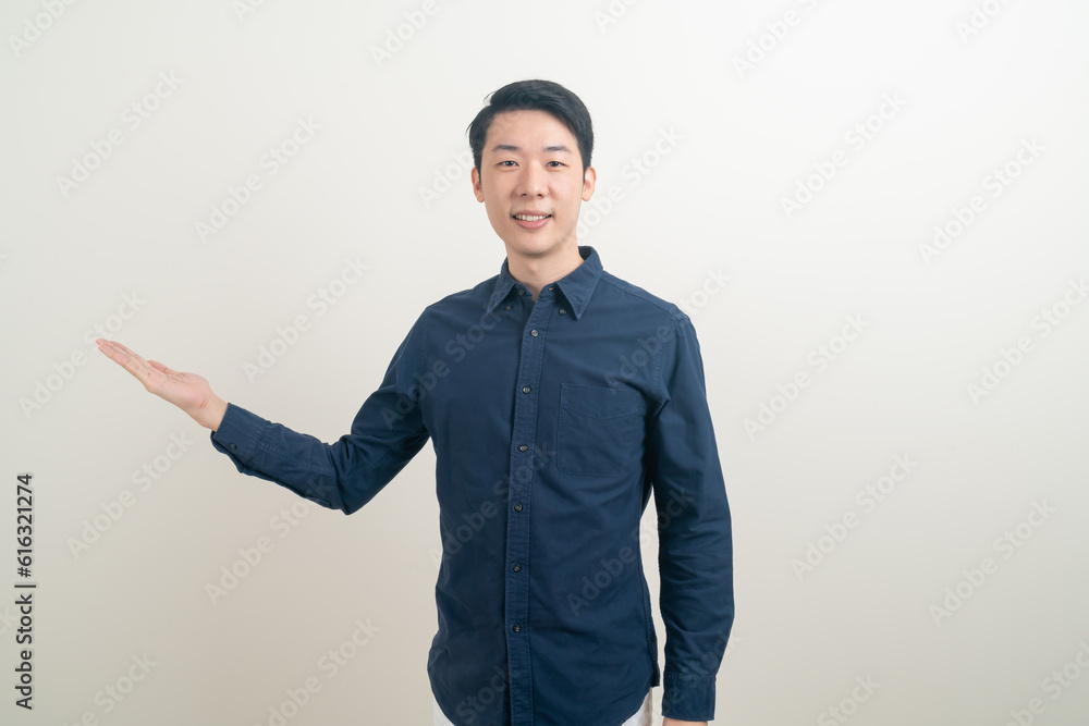 Asian man with hand pointing or presenting on white background Asian man with hand pointing or presenting on white background