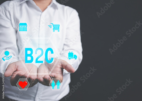Businessman standing holding network icon with text B2C direct merchant to customer or consumer commerce concept. business with customers