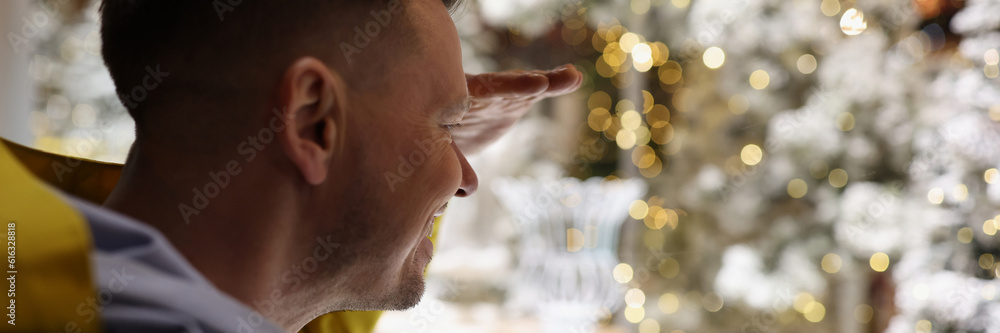 Fototapeta premium Smiling man looking in shop window with christmas decorations