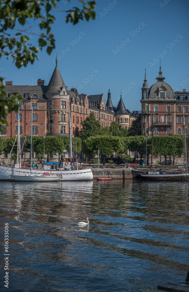 Bay view at Ladugårdslandsviken, boats and old apartment house at the pier Strandvägen , a sunny summer day in Stockholm