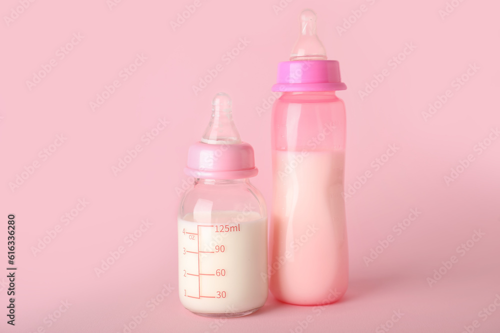 Bottles of milk for baby on pink background Bottles of milk for baby on pink background