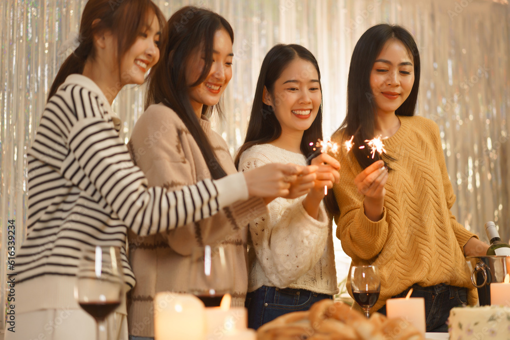 Birthday party concept, Asian girls playing sparklers while dinner celebration in birthday party Birthday party concept, Asian girls playing sparklers while dinner celebration in birthday party