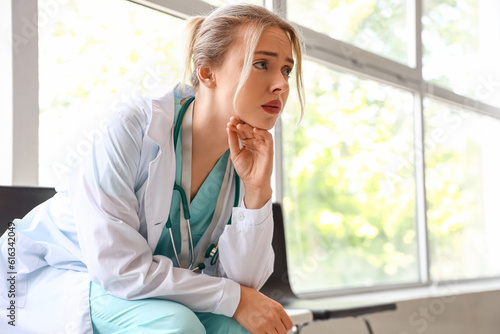 Sad female doctor sitting i...