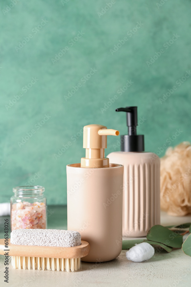 Bottles of cosmetic products, massage brush and sea salt on color background Bottles of cosmetic products, massage brush and sea salt on color background