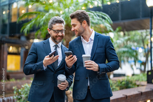 Принти на полотні photo of happy business colleagues with phone and coffee
