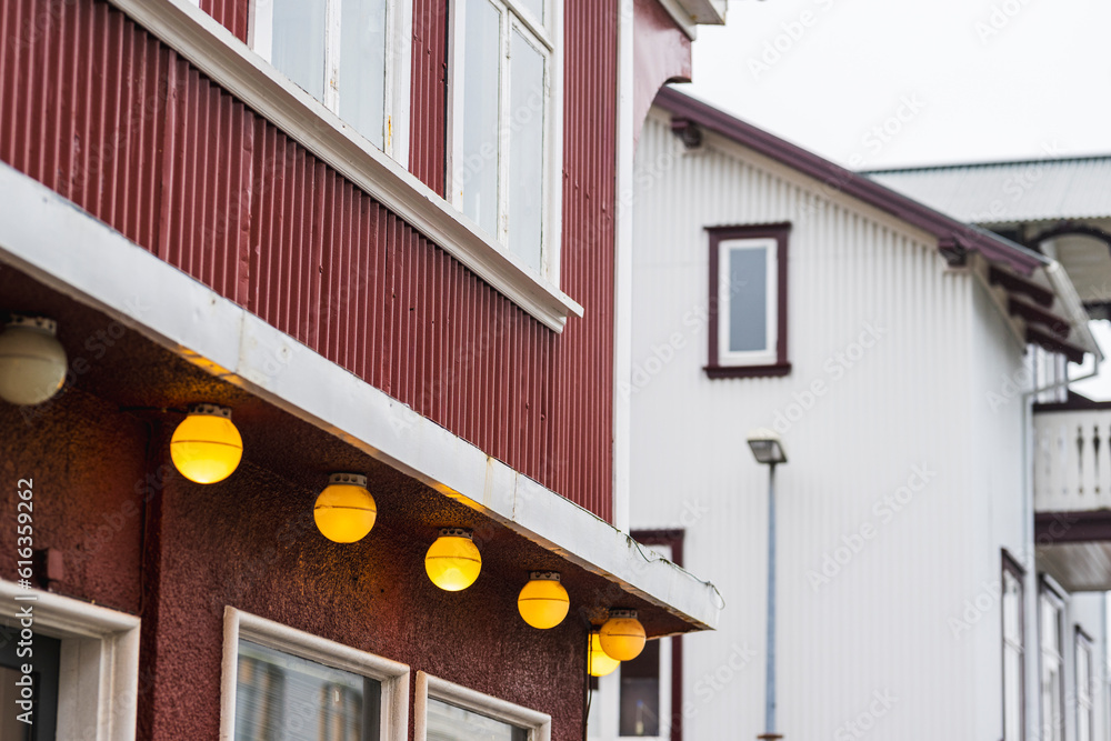 Traditional scandinavian houses made from corrugated iron painted in red and white with yellow lamps
