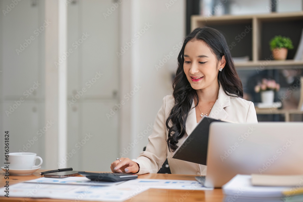 Business woman using calculator and laptop for do math finance on wooden desk in office and business working background, tax, accounting, statistics and analytic research concept. Business woman using calculator and laptop for do math finance on wooden desk in office and business working background, tax, accounting, statistics and analytic research concept.