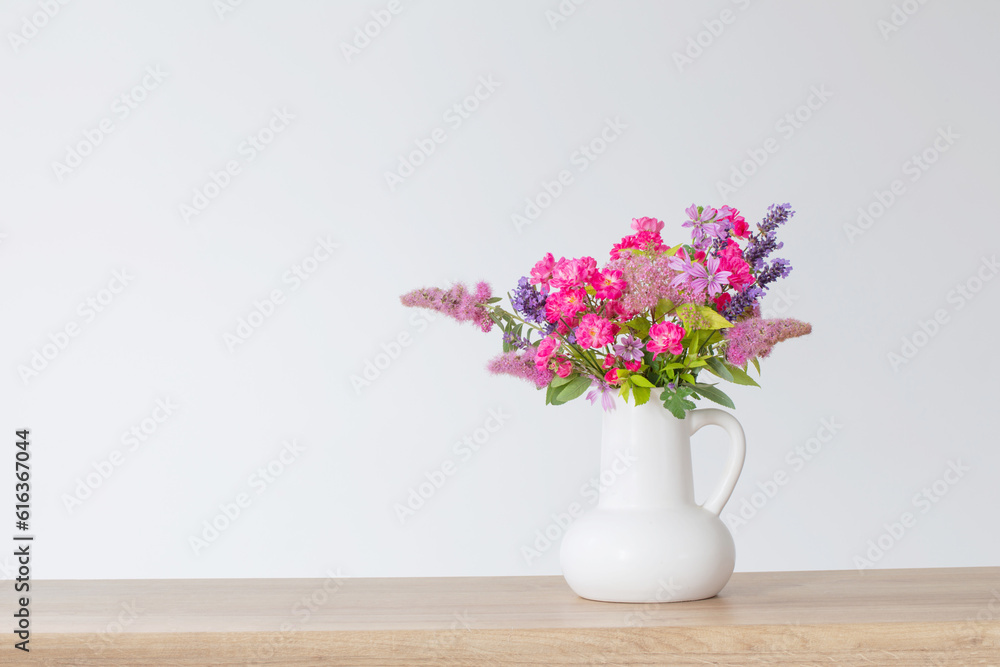 beautiful flowers in white jug on wooden shelf beautiful flowers in white jug on wooden shelf