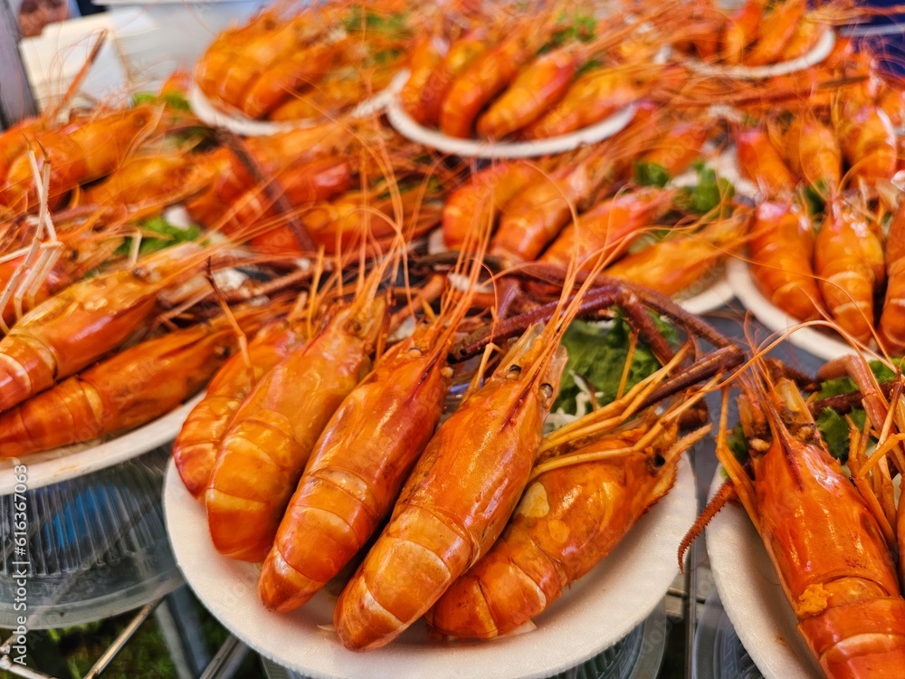 Large steamed river prawns arranged neatly and beautifully on a white plate served with sweet seafood sauce sour prepare to sell to customers in the Thailand market