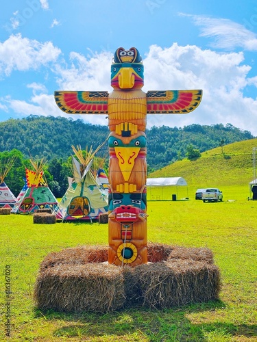 Wooden totem pole isolated in mountain blue background, American indian totem pole in Thailand, June 23, 2023