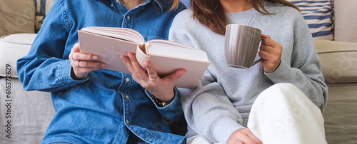 Closeup image of a young couple women enjoyed drinking coffee and reading books together at home © Farknot Architect