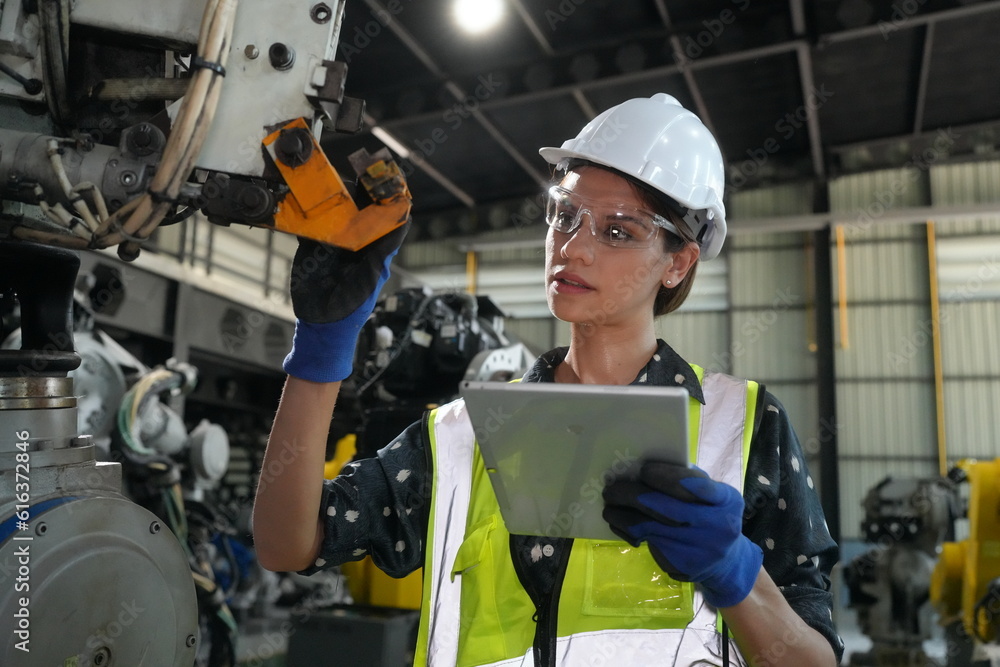 Woman working intently on a complicated industry 4.0 robot plant in technology factory. Woman working intently on a complicated industry 4.0 robot plant in technology factory.