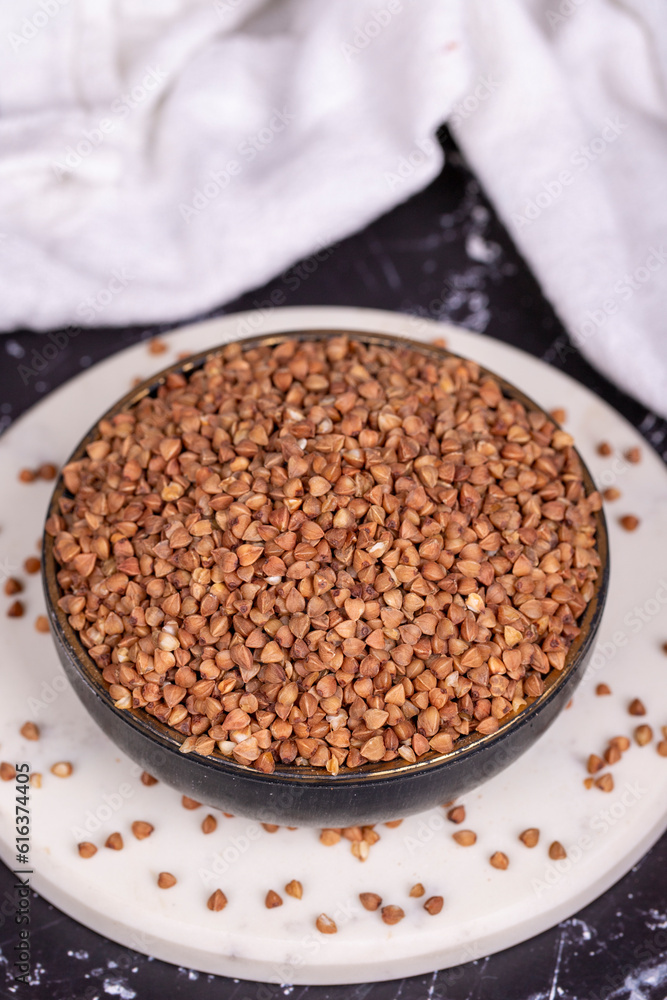 Buckwheat on dark background. Buckwheat grains in bowl Buckwheat on dark background. Buckwheat grains in bowl