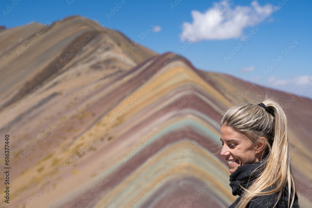 Blonde woman in landscape Rainbow Mountain or Montana Siete Colores, Cuzco, Peru