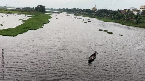 Brahmanbaria, Bangladesh - June 19, 2023, Friends traveling with a small boat on a beautiful river 4K footage. Scenic nature view with a small river. Small river flow aerial view with a wooden boat. photo