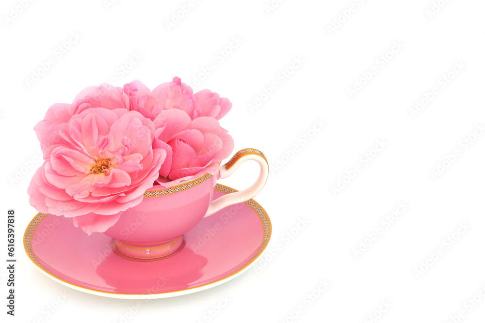 Pink rose flower arrangement in tea cup on white. Surreal fun food composition. Flowers have calming, sedative and anti anxiety health benefits and can reduce risk of heart disease. Pink rose flower arrangement in tea cup on white. Surreal fun food composition. Flowers have calming, sedative and anti anxiety health benefits and can reduce risk of heart disease.
