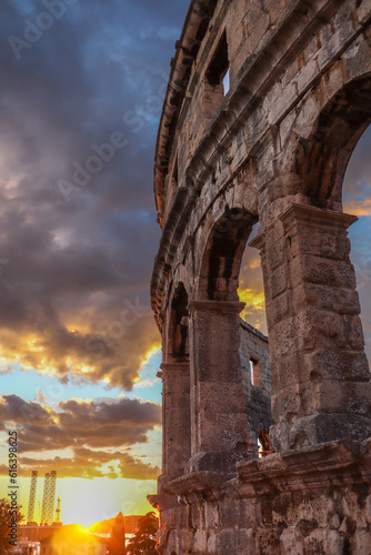 Vertical View of Pula Arena with Sunset Sun during Summer. Golden Hour Sky with Clouds and Roman Amphitheatre in Istrian Croatia.