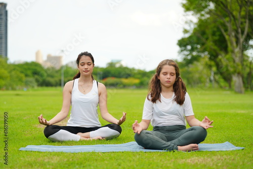 beautiful caucasian mom and little daughter practice yoga and pilates in the park outdoors. healthy lifestyle concept © FotoArtist