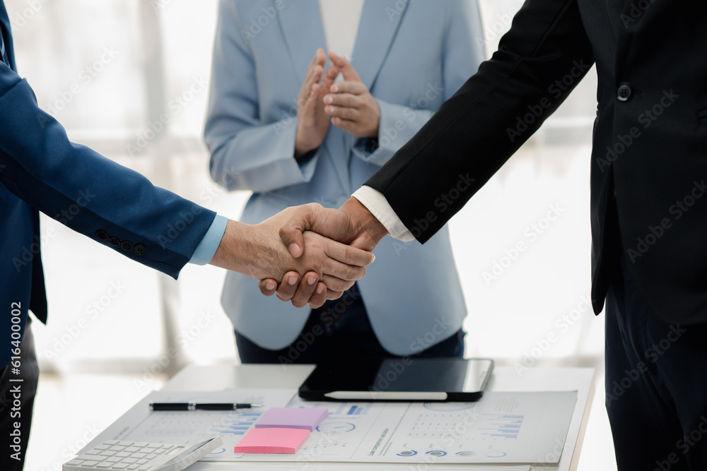 Two businessmen holding hands, Two businessmen are agreeing on business together and shaking hands after a successful negotiation. Handshaking is a Western greeting or congratulation. Two businessmen holding hands, Two businessmen are agreeing on business together and shaking hands after a successful negotiation. Handshaking is a Western greeting or congratulation.