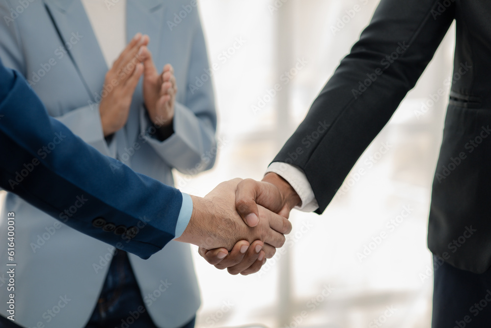 Two businessmen holding hands, Two businessmen are agreeing on business together and shaking hands after a successful negotiation. Handshaking is a Western greeting or congratulation.