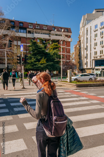 Ginger girl looking for cars while passing pedestrian cross