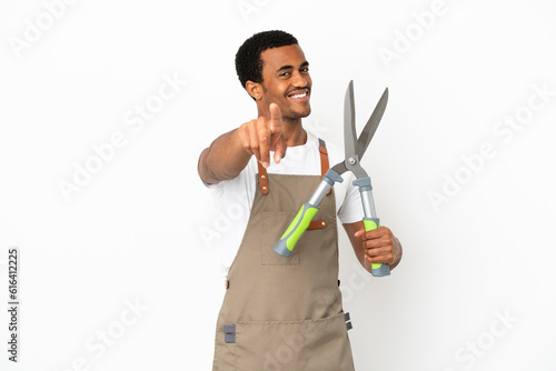 Foto African American gardener man holding pruning shears over isolated white backgro