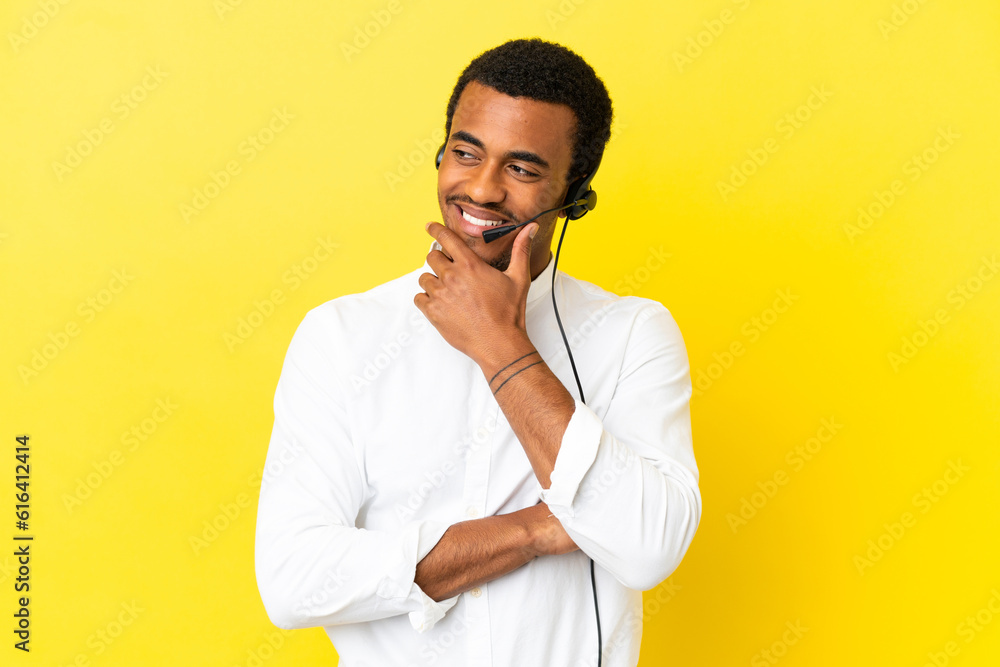 African American Telemarketer man working with a headset over isolated yellow background looking to the side African American Telemarketer man working with a headset over isolated yellow background looking to the side